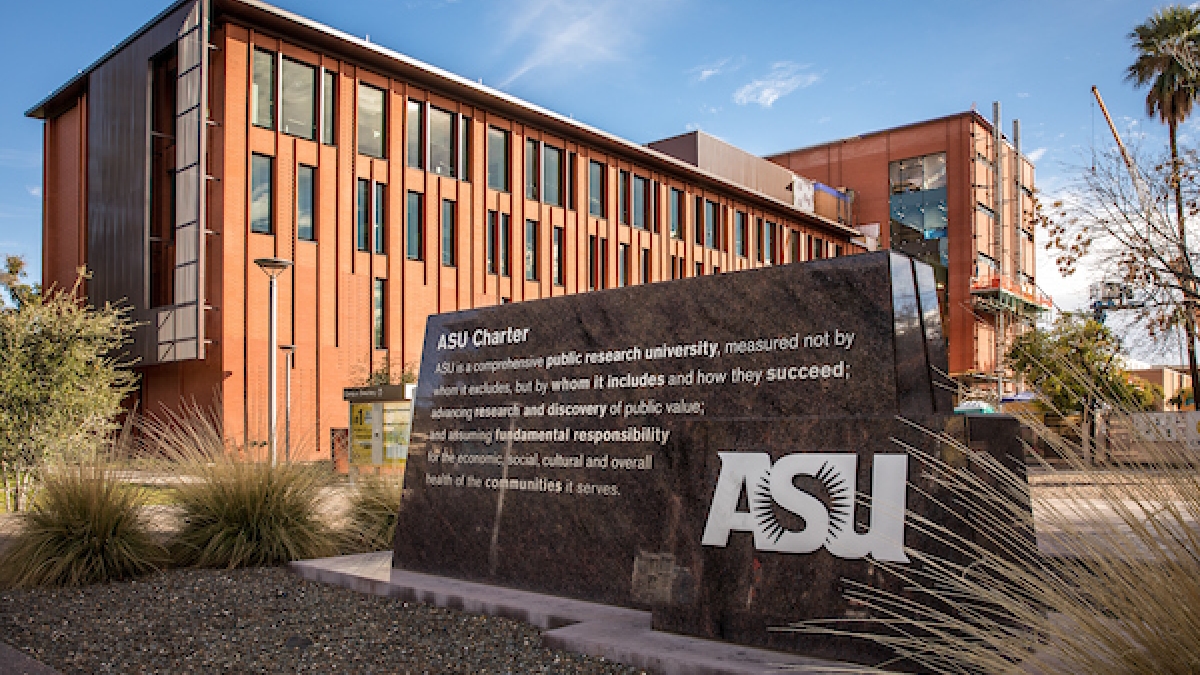 A stone monument of the ASU charter sits outside on a mall on campus. 